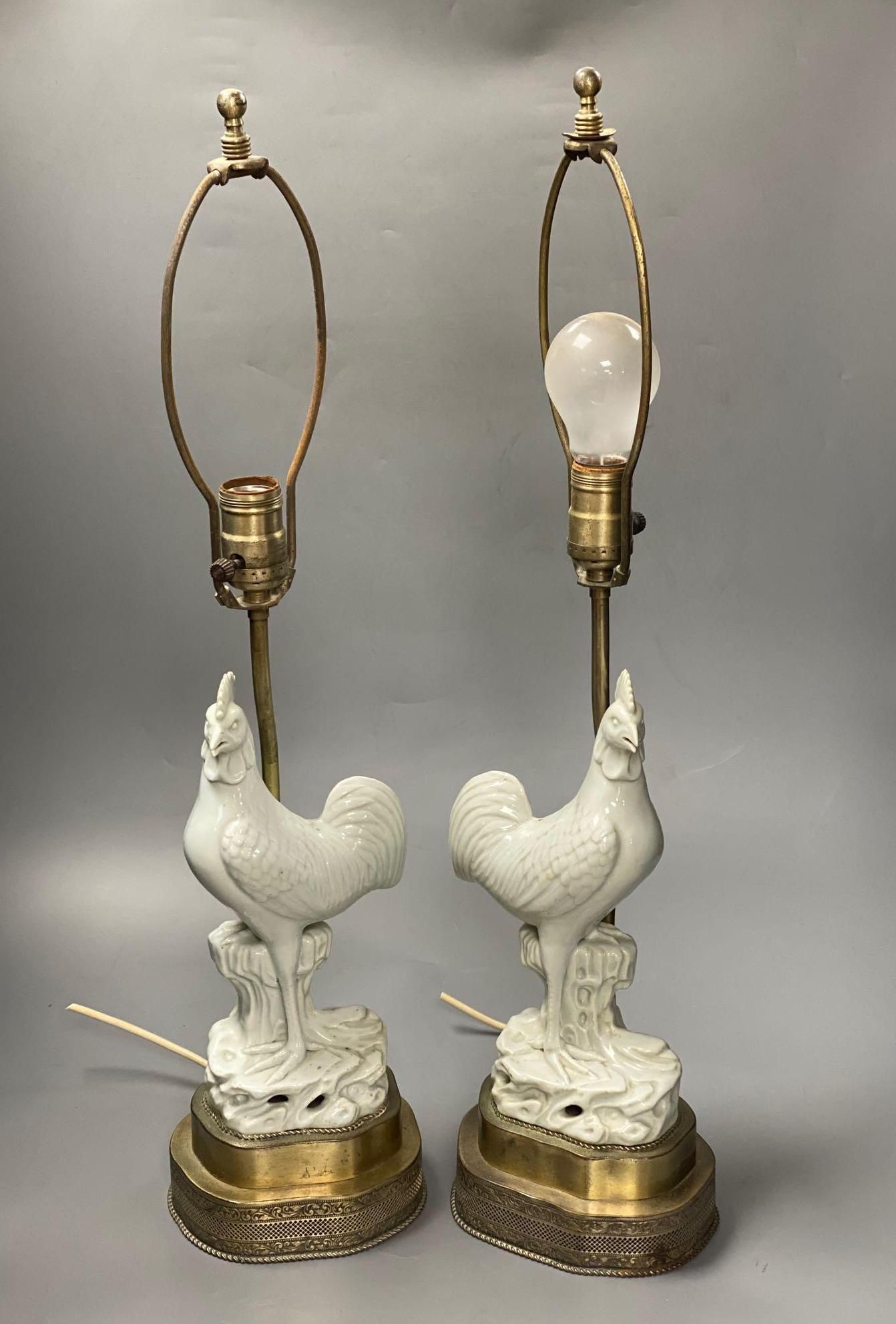 A pair of blanc de chine cockerel lamps, total height 64cm